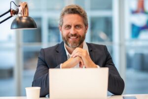 Empresário feliz trabalhando online após vender cota de consórcio PJ e liberar dinheiro para investir no negócio.