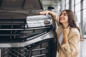 Mulher jovem abraçando o capuz com expressão tranquila, representando sonho realizado com planejamento financeiro pessoal