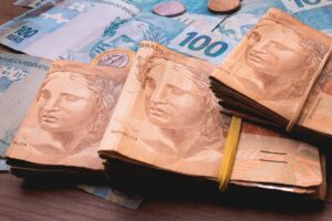 Cédulas de 50 e 100 reais representando planejamento financeiro e estratégias com consórcio.