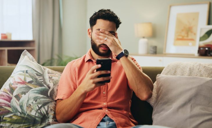 Bad,News,,Phone,And,Stress,With,Man,On,Sofa,In
