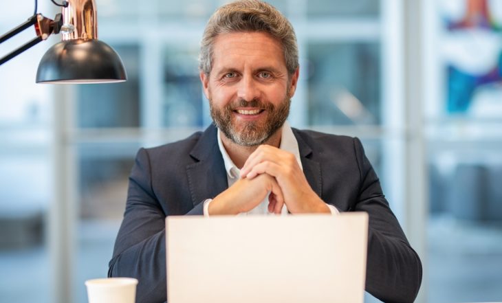 Empresário feliz trabalhando online após vender cota de consórcio PJ e liberar dinheiro para investir no negócio.